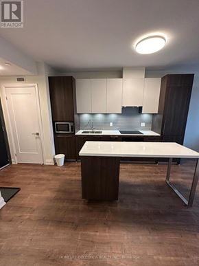 Markham (Unionville) condo for rent - A modern kitchen with a white island and dark wood cabinets.