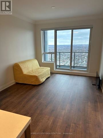 Markham (Unionville) condo for rent - A living room with a yellow chair and a view of the city.