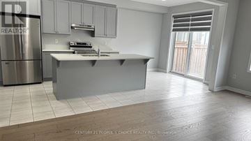 Caledon apartment for rent - A modern kitchen with a stainless steel refrigerator and a central island.