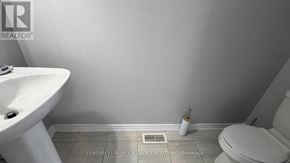 Caledon apartment for rent - A bathroom with a toilet, sink, and a heater on the floor.
