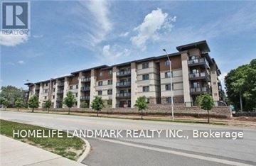 Oakville (Co Central) condo for rent - A building with the text "HOMELIFE LANDMARK REALTY INC., Brokerage" in front of it.