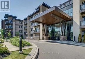 Oakville (Co Central) condo for rent - A modern building entrance with a glass wall and a wooden canopy.