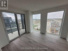 Burlington (Alton) condo for rent - A room with a view of a parking lot and buildings outside the window.