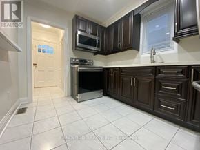 Toronto (Keelesdale-Eglinton West) apartment for rent - A kitchen with brown cabinets and a white tile floor.