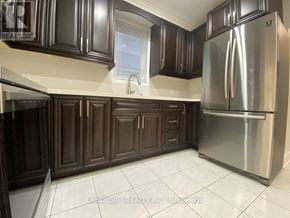 Toronto (Keelesdale-Eglinton West) apartment for rent - A kitchen with dark brown cabinets and a stainless steel refrigerator.