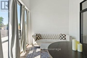 Welland (Broadway) condo for rent - A living room with a white sofa and a black and white checkered pillow.
