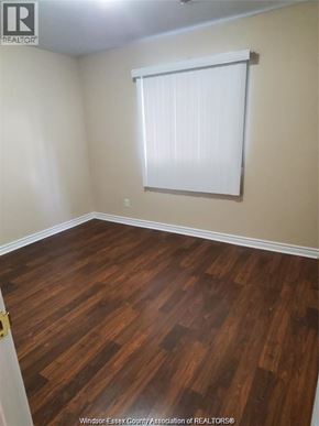 Windsor condo for rent - A room with wooden flooring and a window with blinds.