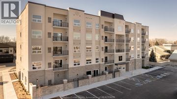 Lasalle condo for rent - A large apartment building with a parking lot in front.