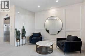 Lasalle condo for rent - A living room with a black couch, a white coffee table, and a round mirror on the wall.
