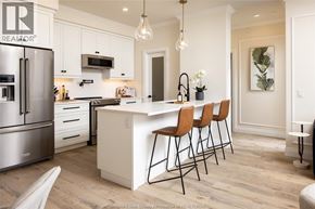 Lasalle condo for rent - A kitchen with white cabinets and a white island with three chairs.