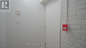 Toronto (Dufferin Grove) condo for rent - A white door with a red fire alarm on the wall.