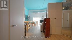 Toronto (Dufferin Grove) condo for rent - A room with a wooden floor and furniture, including a dining table and chairs, is shown.