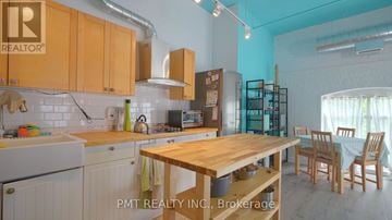 Toronto (Dufferin Grove) condo for rent - A kitchen with wooden cabinets and a table.