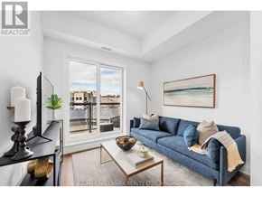 Toronto (Oakridge) townhouse for rent - A living room with a blue couch and a painting on the wall.