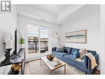 Toronto (Oakridge) townhouse for rent - A living room with a blue couch and a painting on the wall.