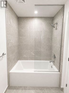 Vaughan (Vaughan Corporate Centre) condo for rent - A white bathtub in a bathroom with grey tiles.