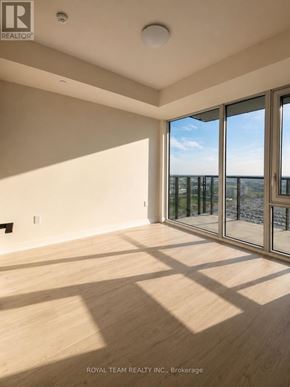 Vaughan (Vellore Village) condo for rent - A room with wooden flooring and a large window overlooking a balcony.