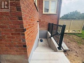 Oakville (Wc Wedgewood Creek) apartment for rent - A brick wall with a black railing and steps leading up to a window.