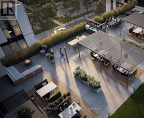 Toronto (Islington-City Centre West) condo for rent - A modern outdoor seating area with a glass roof and people walking around.
