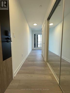 Toronto (Islington-City Centre West) condo for rent - A long hallway with wood floors and white walls.