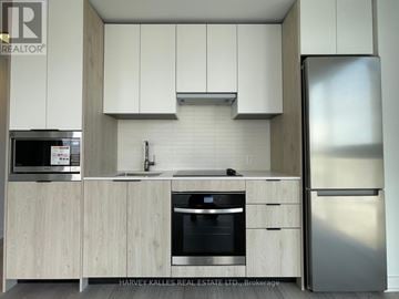 Toronto (Islington-City Centre West) condo for rent - A modern kitchen with wooden cabinets and stainless steel appliances.