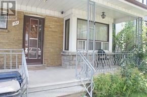 Toronto (Briar Hill-Belgravia) apartment for rent - A house with a brown door and a window with white curtains.