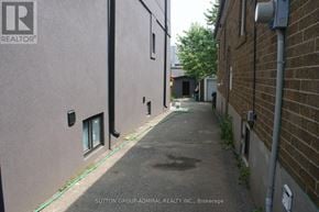 Toronto (Briar Hill-Belgravia) apartment for rent - A narrow alley with a green hose running down the side.