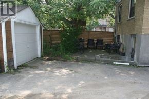 Toronto (Briar Hill-Belgravia) apartment for rent - A backyard with a white garage and a wooden fence.