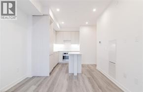 Kitchener condo for rent - A spacious kitchen with white cabinets and a central island.