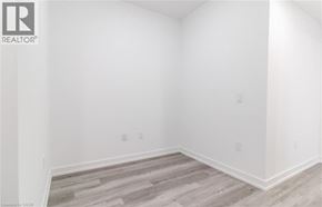 Kitchener condo for rent - A room with a wooden floor and white walls.