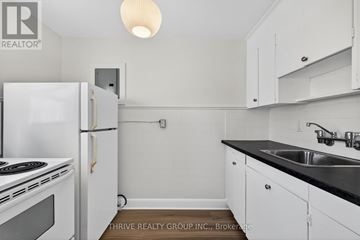 London East (East K) apartment for rent - A small kitchen with white cabinets and a black countertop.