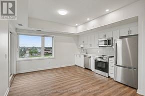 Arnprior condo for rent - A spacious kitchen with stainless steel appliances and wooden flooring.