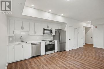 Arnprior condo for rent - A modern kitchen with white cabinets and stainless steel appliances.