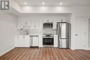 Arnprior condo for rent - A modern kitchen with stainless steel appliances and white cabinets.