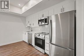 Arnprior condo for rent - A modern kitchen with stainless steel appliances and white cabinets.