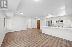 Arnprior condo for rent - A spacious kitchen and living room with wood flooring and white walls.