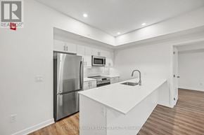 Arnprior condo for rent - A modern kitchen with white cabinets and stainless steel appliances.