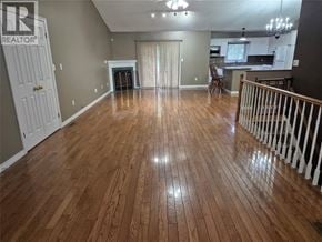 Sarnia apartment for rent - A spacious living room with wooden flooring and a fireplace.