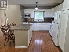 Sarnia apartment for rent - A kitchen with white cabinets and a granite countertop.