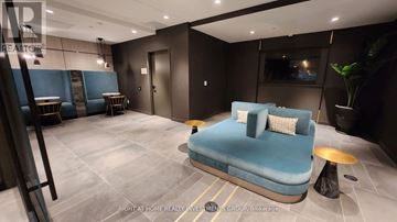 Toronto (Moss Park) condo for rent - A modern living room with a blue sofa and a wooden coffee table.