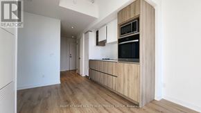 Toronto (Moss Park) condo for rent - A modern kitchen with wooden cabinets and a microwave above the oven.