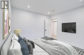 Toronto (The Beaches) condo for rent - A bedroom with a bed, lamp, and painting on the wall.