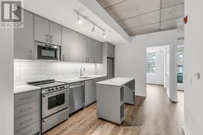 Toronto (South Riverdale) condo for rent - A modern kitchen with stainless steel appliances and white cabinetry.