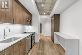 Toronto (South Riverdale) condo for rent - A kitchen with wooden cabinets and stainless steel appliances.