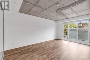 Toronto (South Riverdale) condo for rent - A room with a wooden floor and a window with blinds.