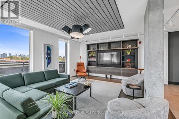 Toronto (South Riverdale) condo for rent - A living room with a green sofa and a grey armchair.