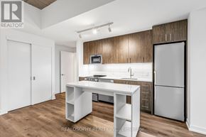 Toronto (South Riverdale) condo for rent - A kitchen with a white table and a refrigerator.