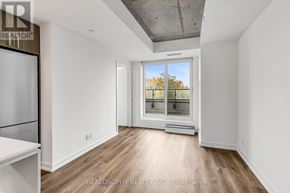 Toronto (South Riverdale) condo for rent - A spacious room with a window overlooking a tree-lined street.