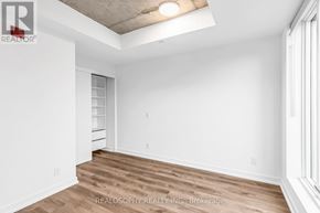 Toronto (South Riverdale) condo for rent - A room with a wooden floor and white walls.