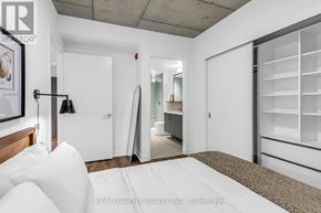 Toronto (South Riverdale) condo for rent - A bedroom with a bed, a lamp, and a wardrobe.